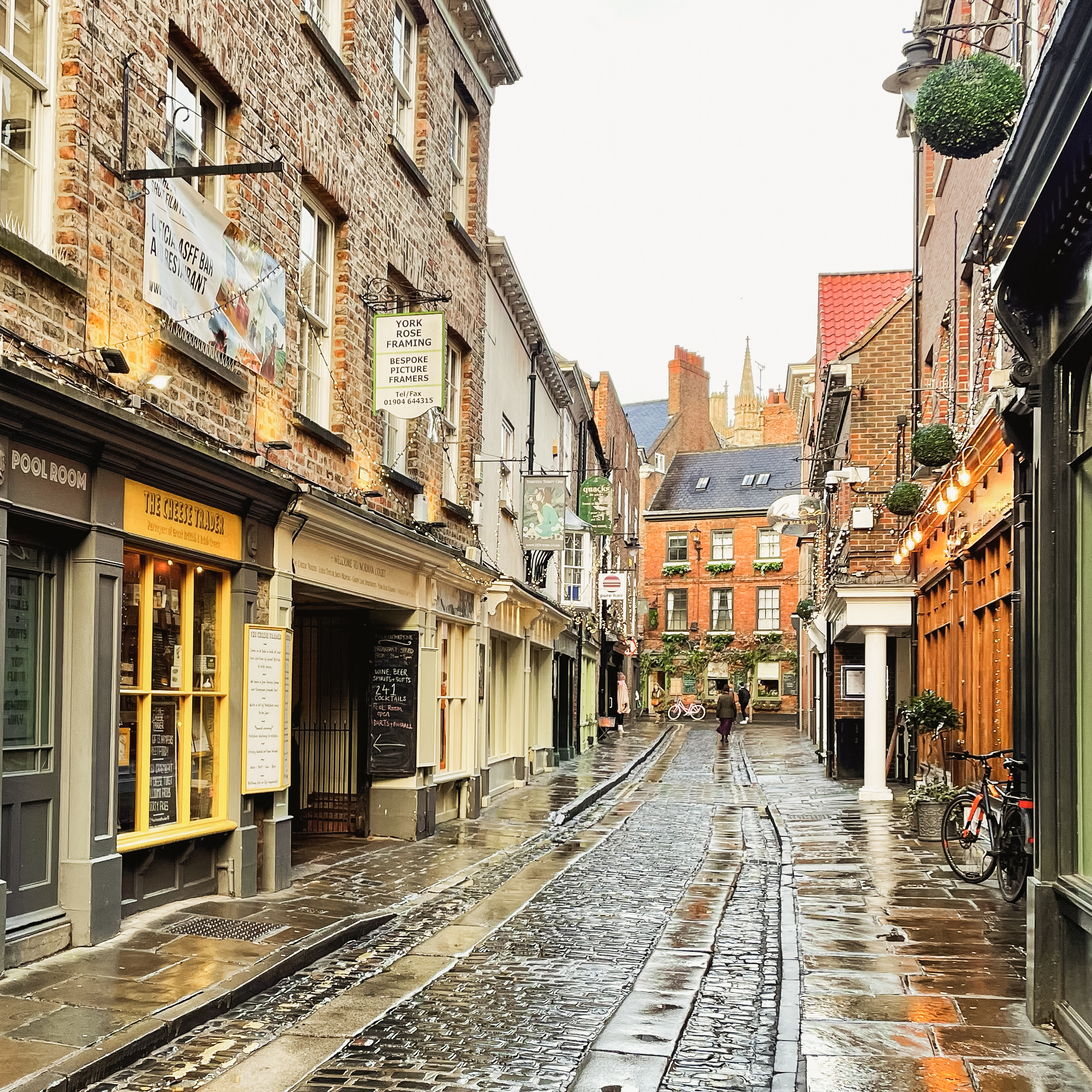 A beautiful cobbled street in York, England, Lined with shops, a post about if York, England is a good place to live